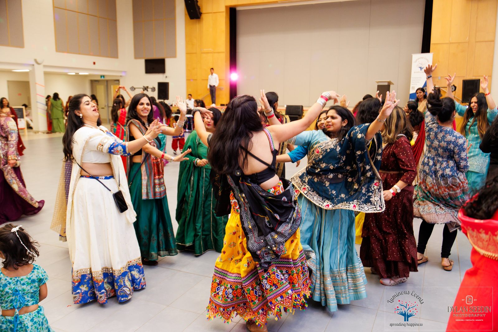 Guests dancing in a lively circle near the stage