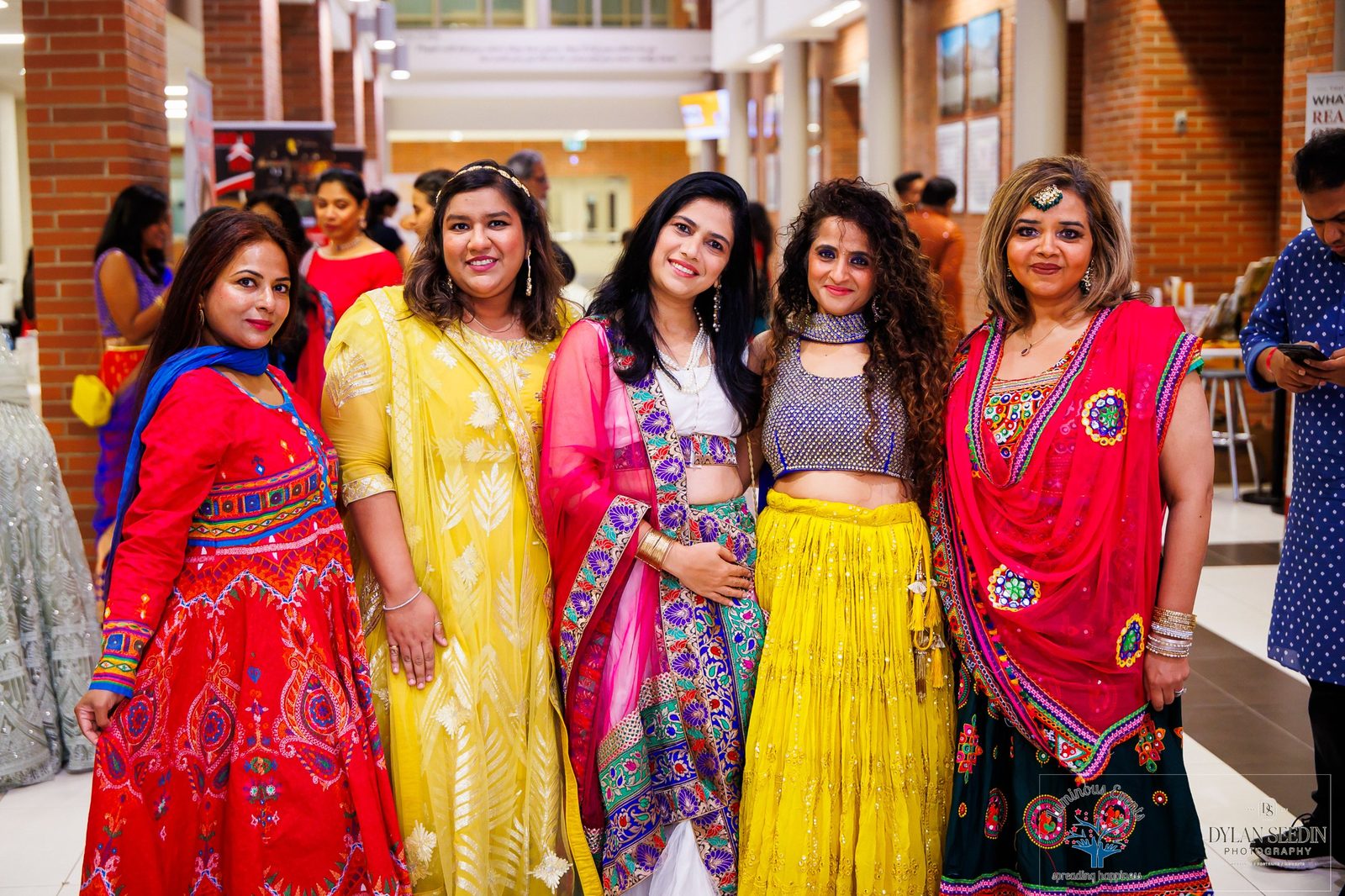 Five friends in bright festive outfits in the school lobby